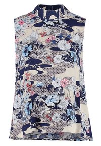Blouse sans manches à col haut, avec un motif floral et de grues en bleu, rose et blanc sur un fond beige et marine.
