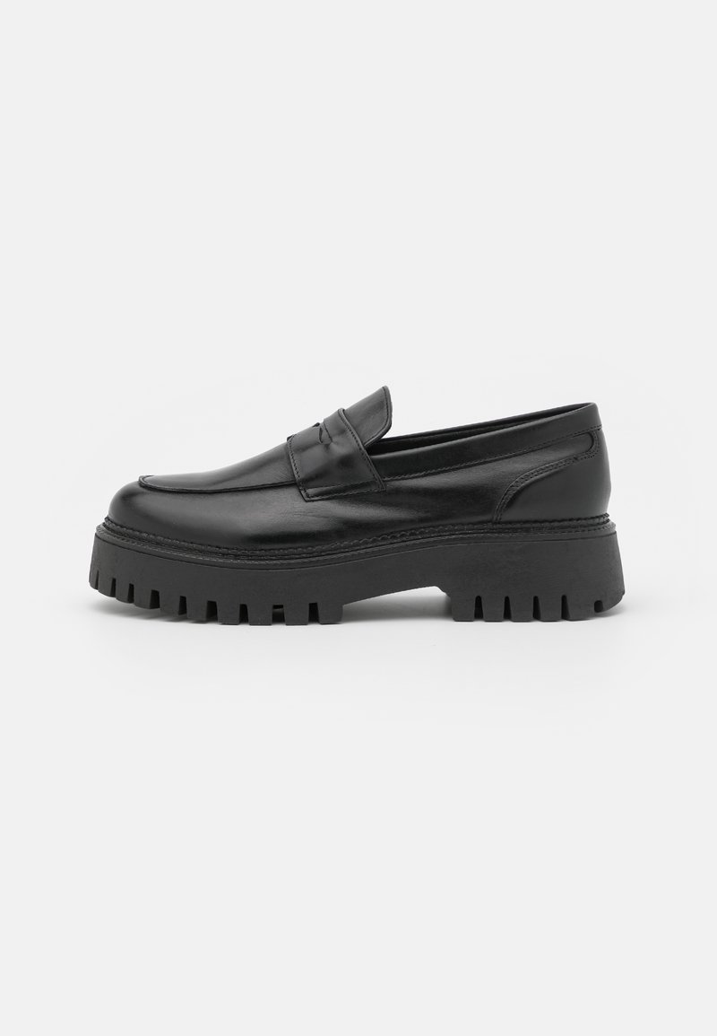 Mocassins en cuir noir avec une semelle extérieure épaisse noire ; avec des détails cousus sur le dessus et une semelle surélevée et texturée pour une meilleure adhérence.