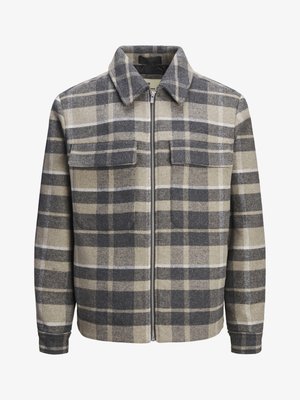 Pilkas, smulkiai raštuotas švarkas, pagamintas iš vilnos, su apykakle, priekiniais užtrauktukais ir dviem krūtinės kišenėmis. Turi neformalią, dėžutę primenančią siluetą.