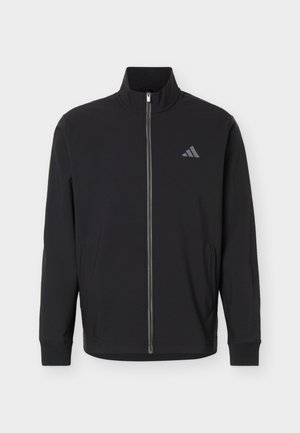 Czarna kurtka na pełny zamek z stojącym kołnierzem, długimi rękawami, bocznymi kieszeniami i małym szarym logo Adidas na lewej piersi.