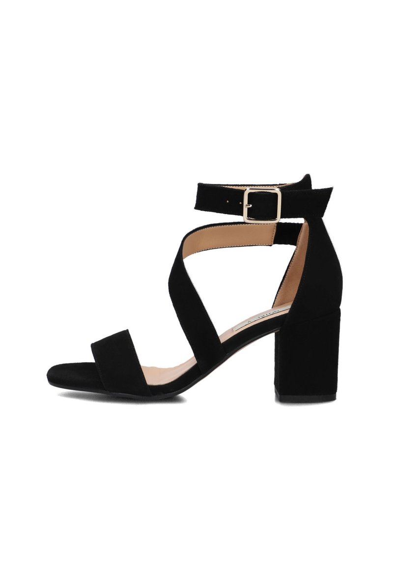 Zwarte suède heeled sandalen met een blokhak, twee brede voorkruisbanden en een enkelband met een metalen gespsluiting.