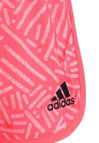 Bolsa deportiva rosa con un patrón geométrico blanco texturizado y un logotipo negro de Adidas. Material liso con ribete en contraste.