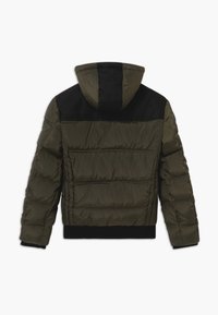 Padded olive green jacket with a black upper panel and hood. Features elastic cuffs and hem, with horizontal seams for structure.