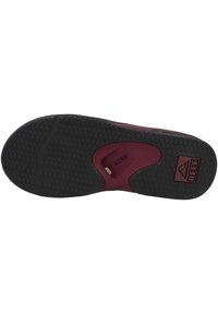 Black rubber outsole with a textured pattern, burgundy midsole, featuring the "REEF" logo and a circular cutout for enhanced grip.