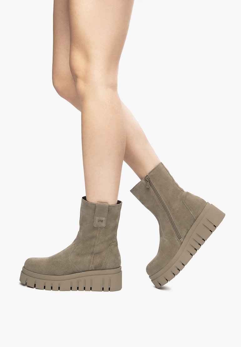 Braune Wildlederschuhe bis zu den Knöcheln mit einer dicken, geriffelten Sohle und einem Reißverschluss an der Seite. Das Design verfügt über eine Anziehhilfe auf der Rückseite für ein einfaches Anziehen.