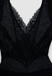 Body noir avec un décolleté en V, une bordure en dentelle florale et un tissu texturé. Le design intègre des éléments doux et translucides pour plus de détails.