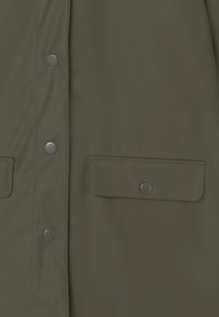 Cappotto verde oliva con bottoni a pressione e due tasche frontali con pattina, realizzato in tessuto morbido e resistente all'acqua.