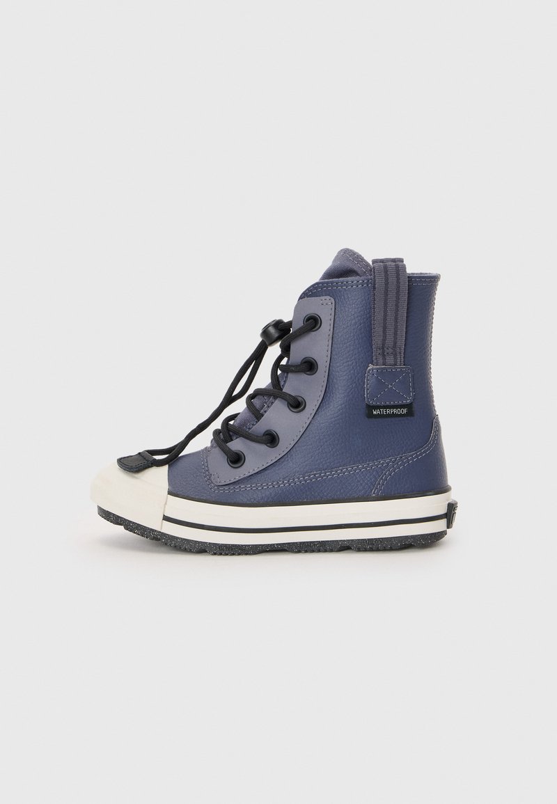 Waterproof navy blue high-top boots with black laces, rubber toe cap, white stripe on the sole, and a fabric pull tab at the back.