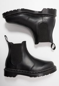 Black rubber Chelsea boots with elastic side panels, textured fabric accents, a rounded toe, and a rugged outsole. Loop tabs for easy wear.