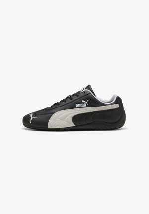 Zwarte leren sneakers met een gestructureerde grijze suède streep, voorzien van witte logo-accenten en een vetersluiting, ronde neus en rubberen zool.