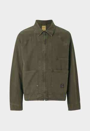 Olivgrüne Jacke mit Reißverschluss vorne, spitzem Kragen und zwei Fronttaschen. Hergestellt aus strapazierfähigem Stoff mit sichtbaren Nähdetails.