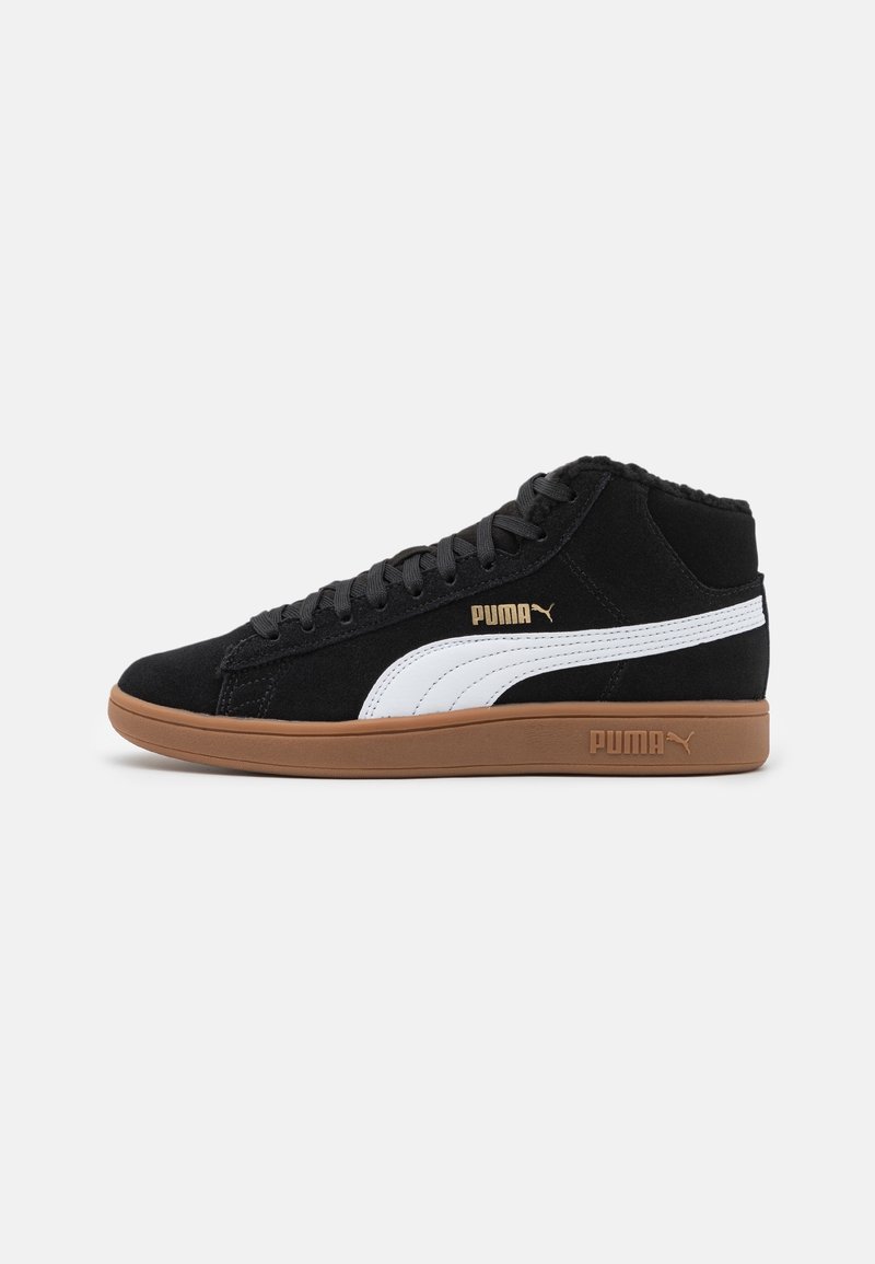 Baskets montantes Puma noires avec bande blanche, semelle marron et logo Puma doré sur le côté et le talon sur fond uni.