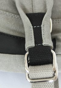 Grauer Leinengurt mit schwarzem Textil und silberner Metallschnalle. Verfügt über verstärkte Nähte und eine glatte Textur. Nahaufnahme.