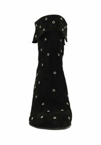 Bottine en daim noir à bout pointu, ornée de rivets argentés et d'un revers rabattable. Texture lisse avec une silhouette ajustée.