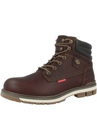Botas de senderismo de cuero marrón con un cuello acolchado, ojales de metal, cordones beige y una suela resistente. Presenta una pequeña etiqueta de marca roja.