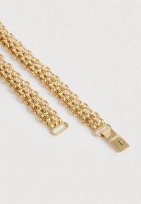 Armbånd i guldkæde med sammenlåste cirkulære led, glat tekstur og lukning med lås. Mål cirka 2,5 cm i bredden.