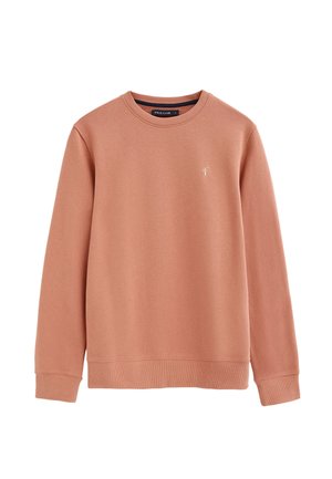 Jasnobrązowa bluza crewneck z długimi rękawami, ściągaczami na mankietach i dole oraz małym białym haftowanym logo na lewej piersi.