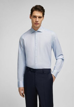 Light blue checkered button-up shirt with a collar, long sleeves, and a slim fit, paired with dark navy trousers. Smooth fabric texture.