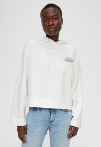 Weißer, verkürzter Kapuzenpullover mit langen Ärmeln und verstellbarem Kapuzenschnürzug. Mit Textgrafik auf der oberen linken Seite und einer glatten, weichen Textur.