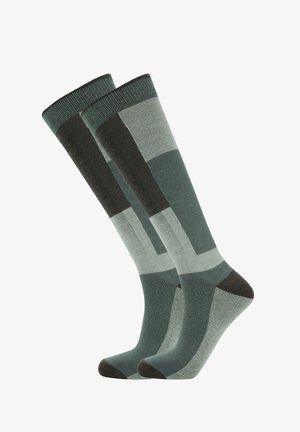 Chaussettes montantes présentant un motif géométrique dans des nuances de vert et de gris, avec un orteil gris foncé et un talon renforcé pour plus de durabilité.