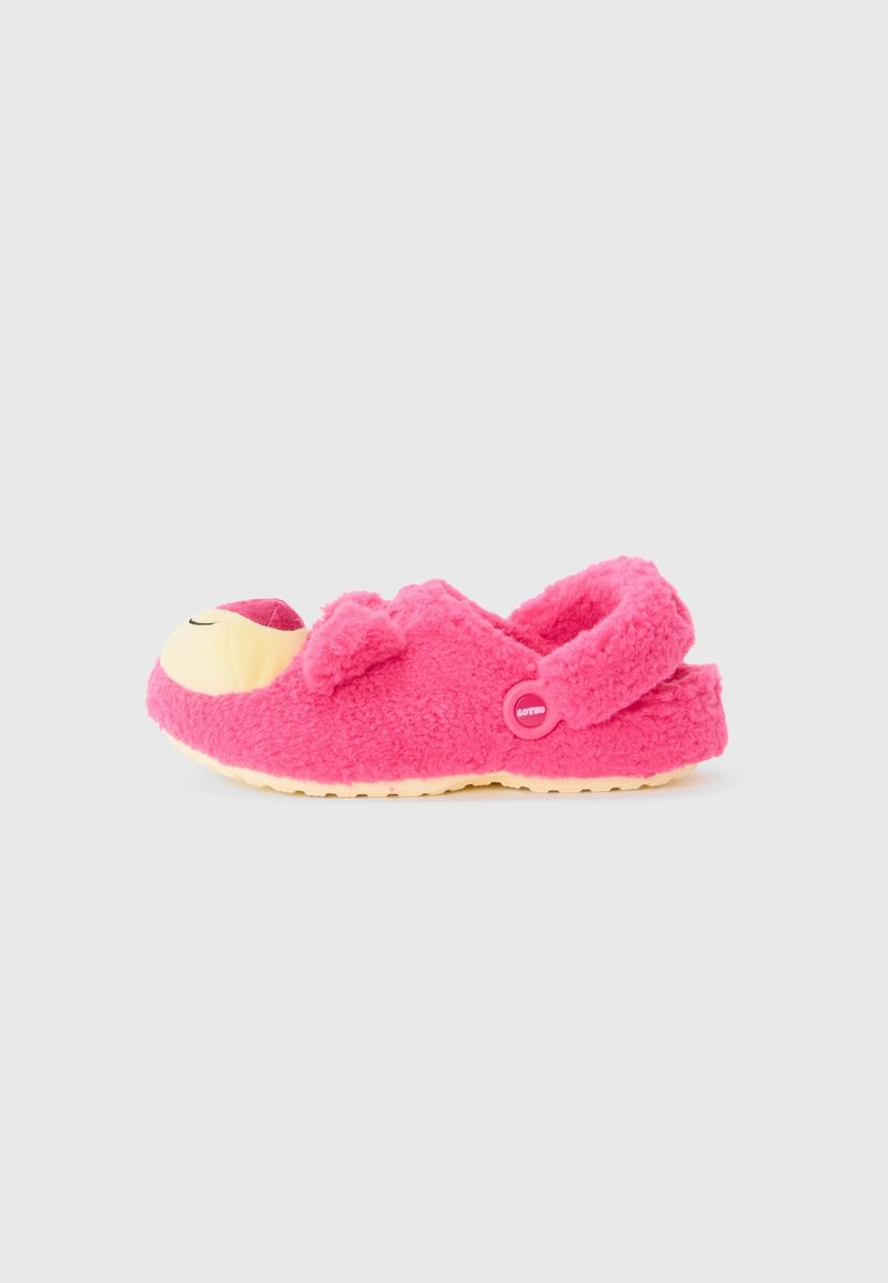 Chaussure enfant rose duveteuse à enfiler avec un visage souriant sur l'orteil et une bride avec un bouton au talon.