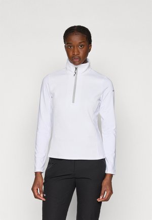 Fleece alb cu fermoar, cu guler înalt, suprafață texturată, mâneci lungi și fermoar contrastant. Asortat cu pantaloni negri.