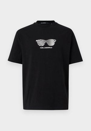 Schwarzes T-Shirt mit kurzen Ärmeln und weißem Grafikdruck gestreifter Sonnenbrillen sowie dem Text "KARL LAGERFELD" mittig auf der Brust.