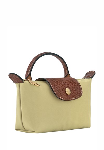 Beige fabric handbag with brown textured leather details, a rounded handle, and gold hardware, featuring a flap closure and zip compartment.