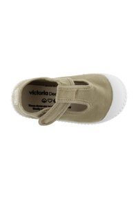 Zapato tipo slip-on de lona verde con suela de goma blanca, que presenta una correa frontal y un diseño recortado para transpirabilidad. Logo visible en el interior.