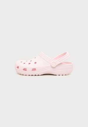 Jasnoróżowe chodaki typu slip-on z otworami wentylacyjnymi, teksturowaną podeszwą i regulowanym paskiem na piętę.
