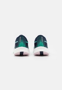 Pair of navy and green Reebok running shoes viewed from the back, showing textured white midsoles and pink outsoles on a white background.