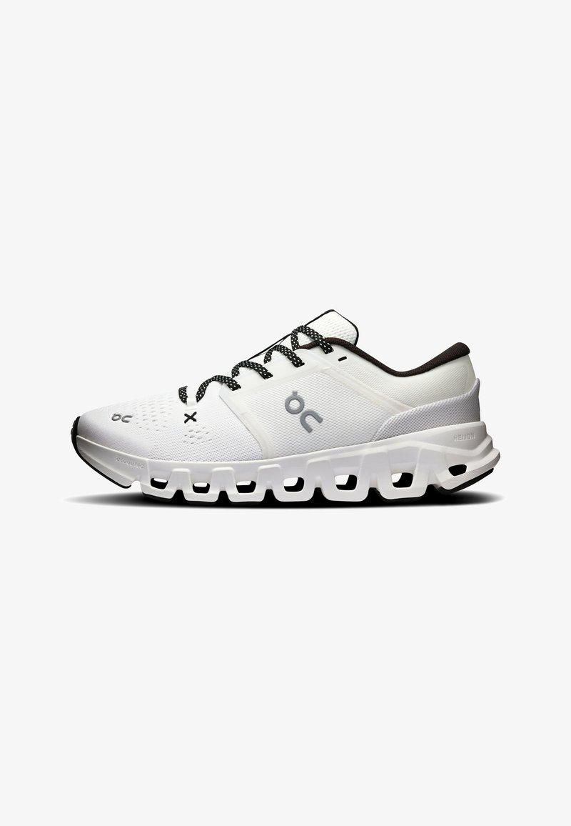 Chaussure de sport blanche avec lacets noirs et blancs, doublure intérieure noire, dessus ventilé et semelle segmentée distinctive pour amorti et maintien.