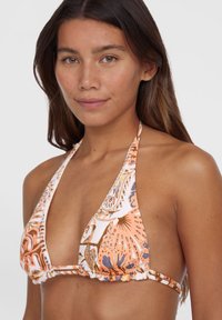 Narancssárga és fehér színű háromszög bikini top virágmintával; húzózsinóros pántokkal és ráncolt anyaggal az élein.