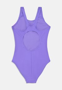 Enkelt delet badedrakt i lys lilla. Har brede stropper, åpen rygg med sirkulært utsnitt, og glatt, elastisk stoff. Minimale sømmer.
