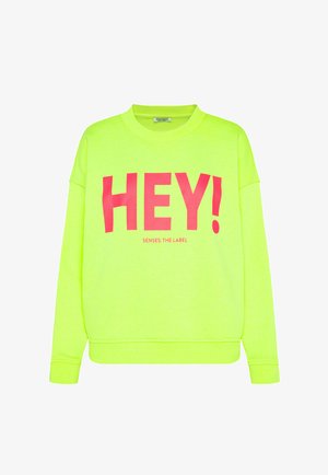 Neon green long-sleeve sweatshirt with bold pink "HEY!" text and smaller "SENSES. THE LABEL" branding on the front.