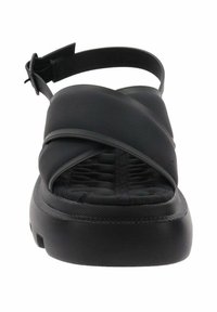 Zwarte sandalen met een kruisstrapontwerp, gemaakt van zachte materialen. Heeft een dikke, gestructureerde zool voor extra grip en comfort. Verstelbare achterkant.
