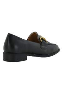 Mocasines de cuero negro con un tacón bajo, que presentan un detalle de hebilla en tono dorado y una textura suave. Diseño clásico con punta redonda.
