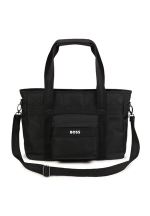 Sac fourre-tout noir en tissu avec poignées doubles et bandoulière réglable, doté d'une poche avant avec logo et d'une surface texturée.