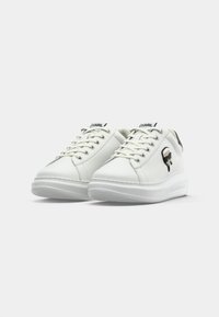 Vita Karl Lagerfeld låga sneakers med snörning, med en liten tecknad logotyp på sidan och en ren, minimalistisk design.