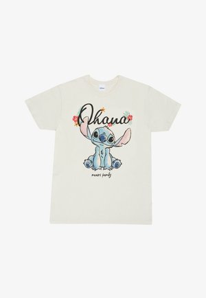 Crème katoen t-shirt met een cartoonfiguur met blauwe huid en grote oren, omringd door de tekst "Ohana betekent familie" en bloemaccenten.