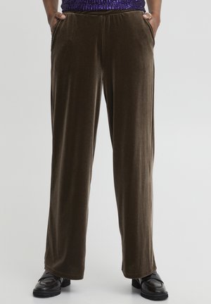 Brown velvet trousers with a straight leg design, featuring side pockets and a soft texture, paired with black shiny shoes.