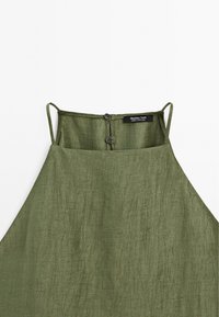 Green linen top with spaghetti straps, a button closure at the back, and a textured finish. Label reads "Massimo Dutti."