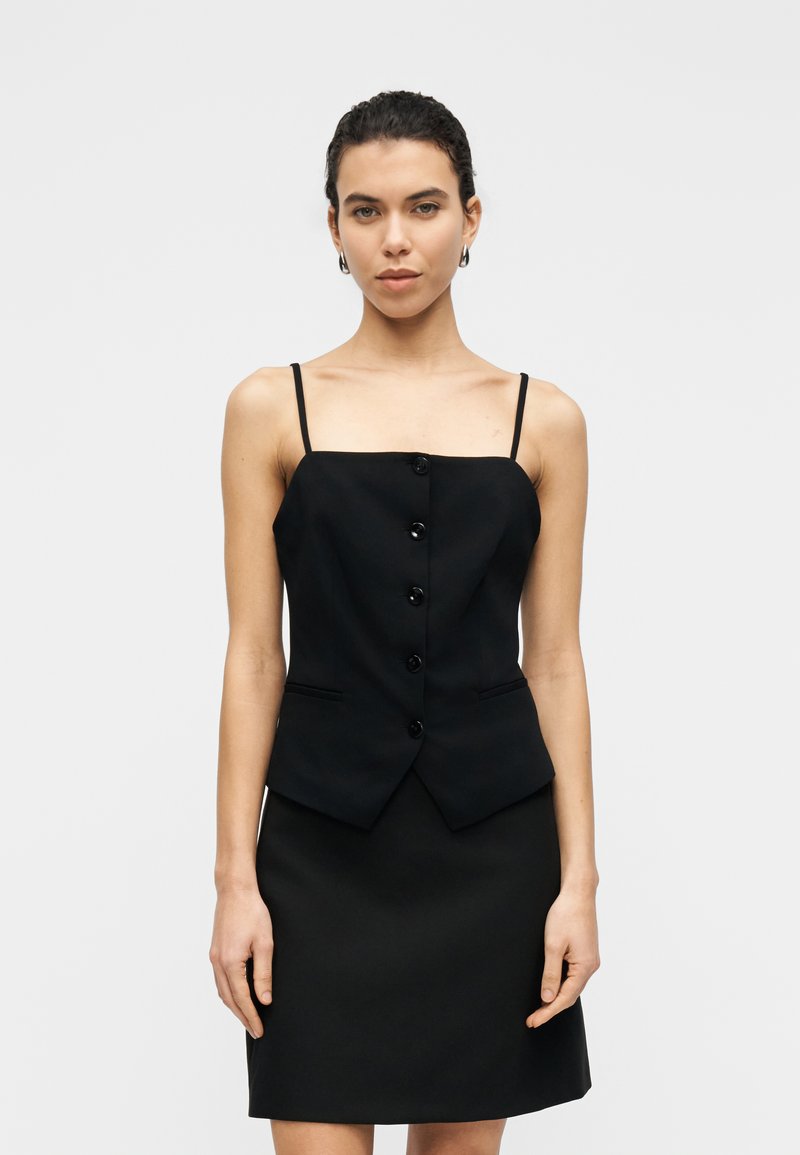 Μαύρο εφαρμοστό τοπ με λεπτές τιράντες, με τετράγωνη λαιμόκοψη και έξι κουμπιά μπροστά. Το ύφασμα έχει λεία υφή.