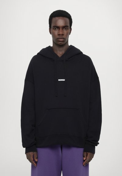 Črna kapuca s sprednjim žepom in vrvico. Značilna bela logotip "BONSAI" na prsih. Mehka tkanina, sproščen kroj, rebrastimi manšetami.