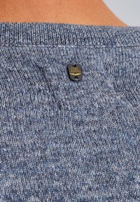 Maglione blu lavorato a maglia con un motivo testurizzato. Presenta un'etichetta nera con "PME LEGEND" in lettere dorate attaccata vicino al collo.