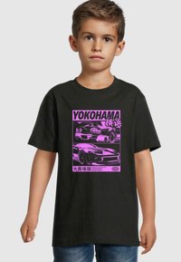 Černé bavlněné tričko s růžovou grafikou dvou aut a japonským textem, umístěným v obdélníkovém designu. Krátké rukávy a kulatý výstřih.