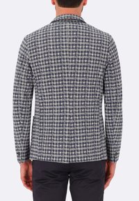 Blazer a scacchi navy e bianco con texture, colletto a punta, due tasche e polsini con bottone, visto da dietro.