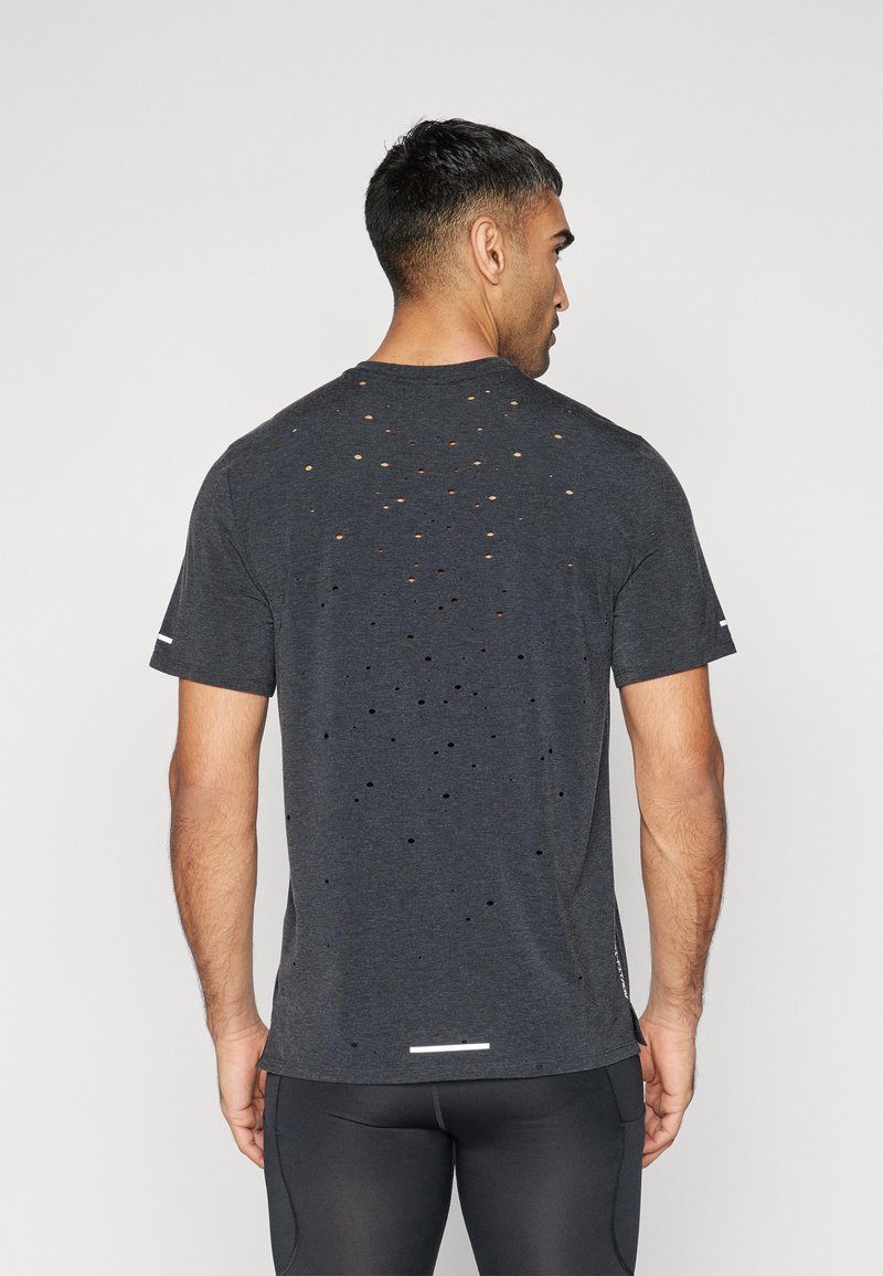 T-shirt a maniche corte da uomo in tessuto grigio scuro con numerosi buchi intagliati sulla schiena per la traspirabilità e un accento riflettente sulla manica.