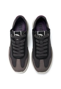 Zapatillas negras y grises con parte superior texturizada, cierre de cordones y plantilla morada. Presentan un cuello acolchado y suela de goma.