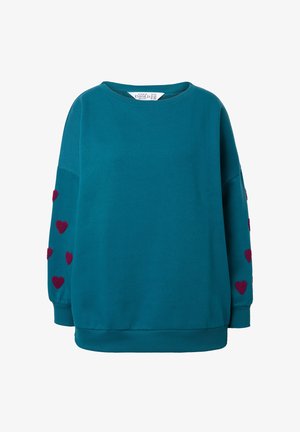 Sudadera de gran tamaño en color azul verdoso, fabricada en algodón, con corazones burdeos bordados a lo largo de las mangas y un cuello redondeado.